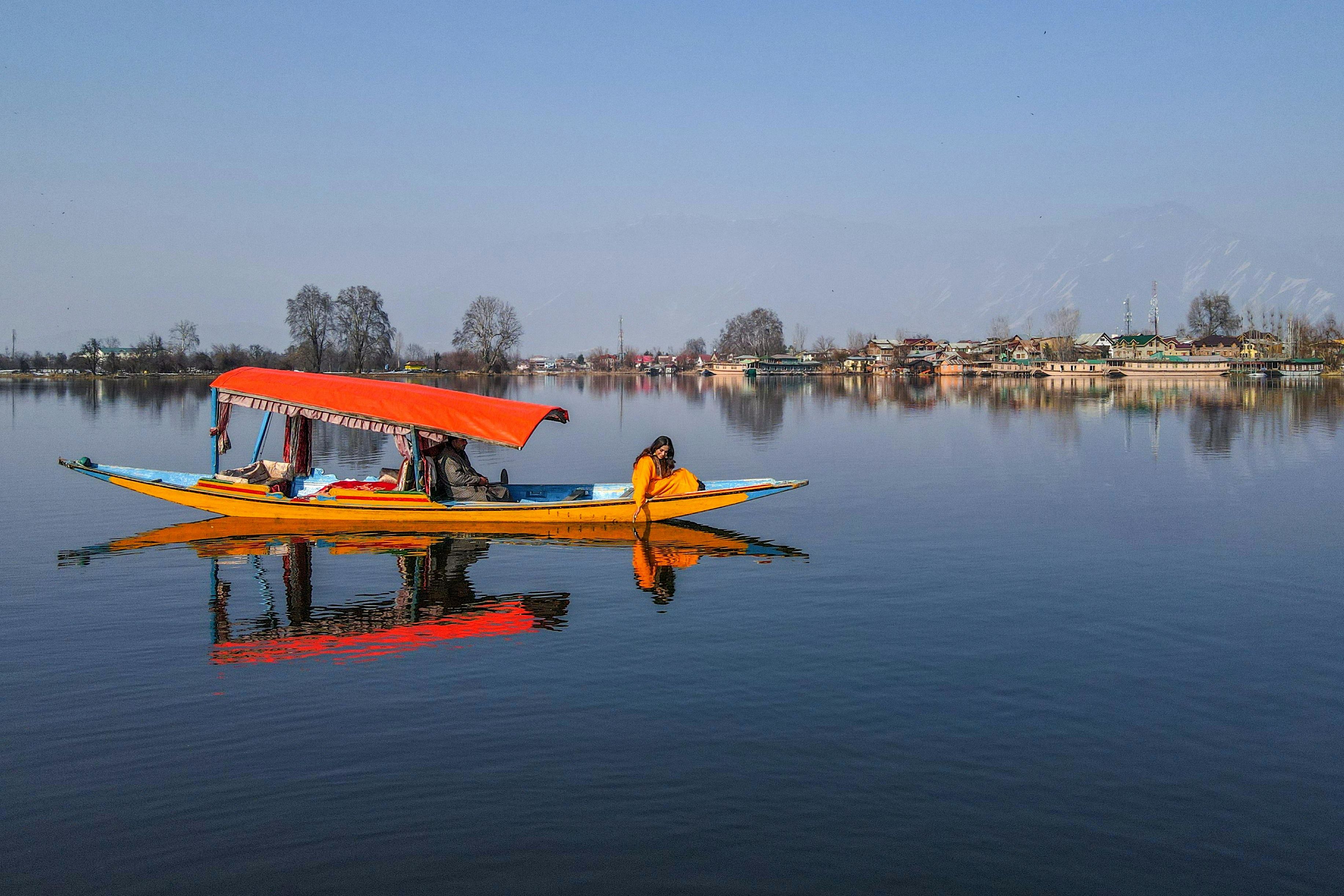 a woman sitting on a shikara boat in dal lake