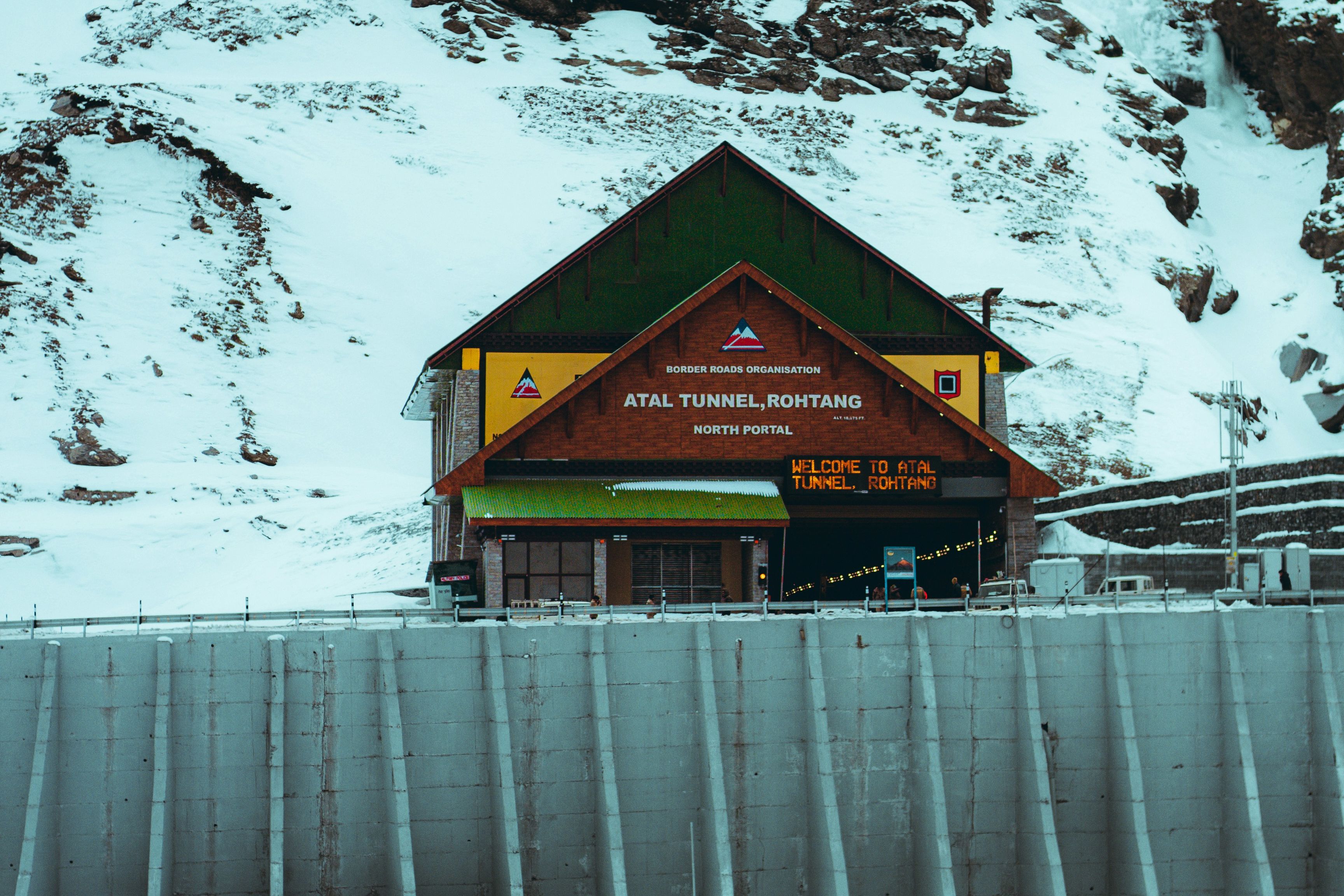 north portal of atal tunnel with snow covered mountains in the backdrop