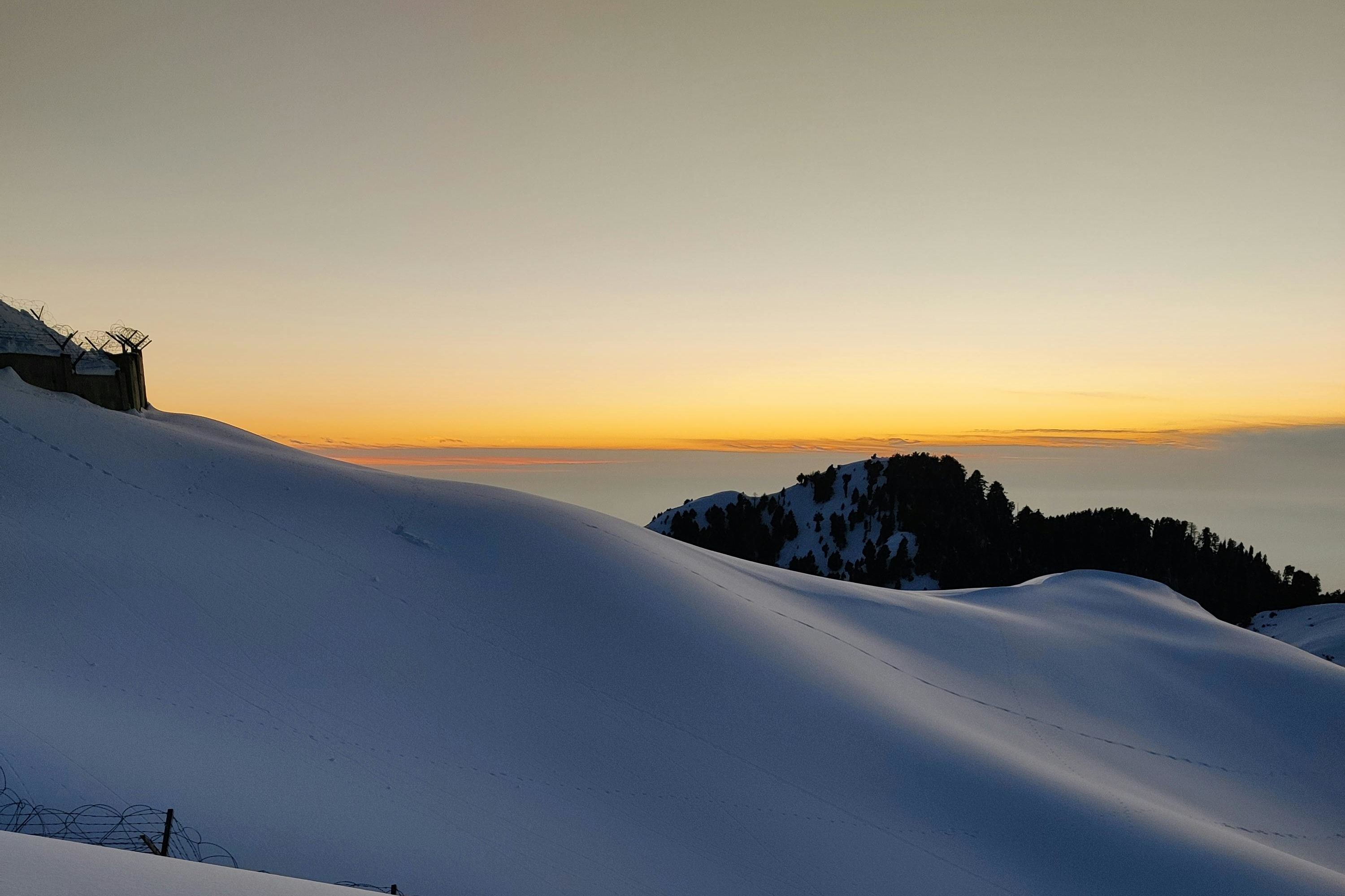 snow covered mountain in dalhousie during sunset