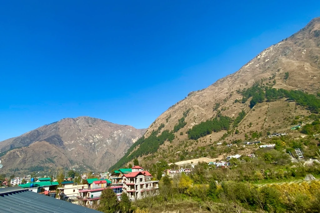 houses in a valley in bhuntar surrounded by grey mountains