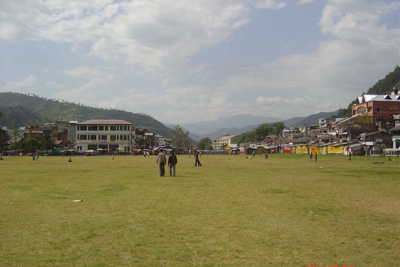 people waling on a green field in chamba during daytime