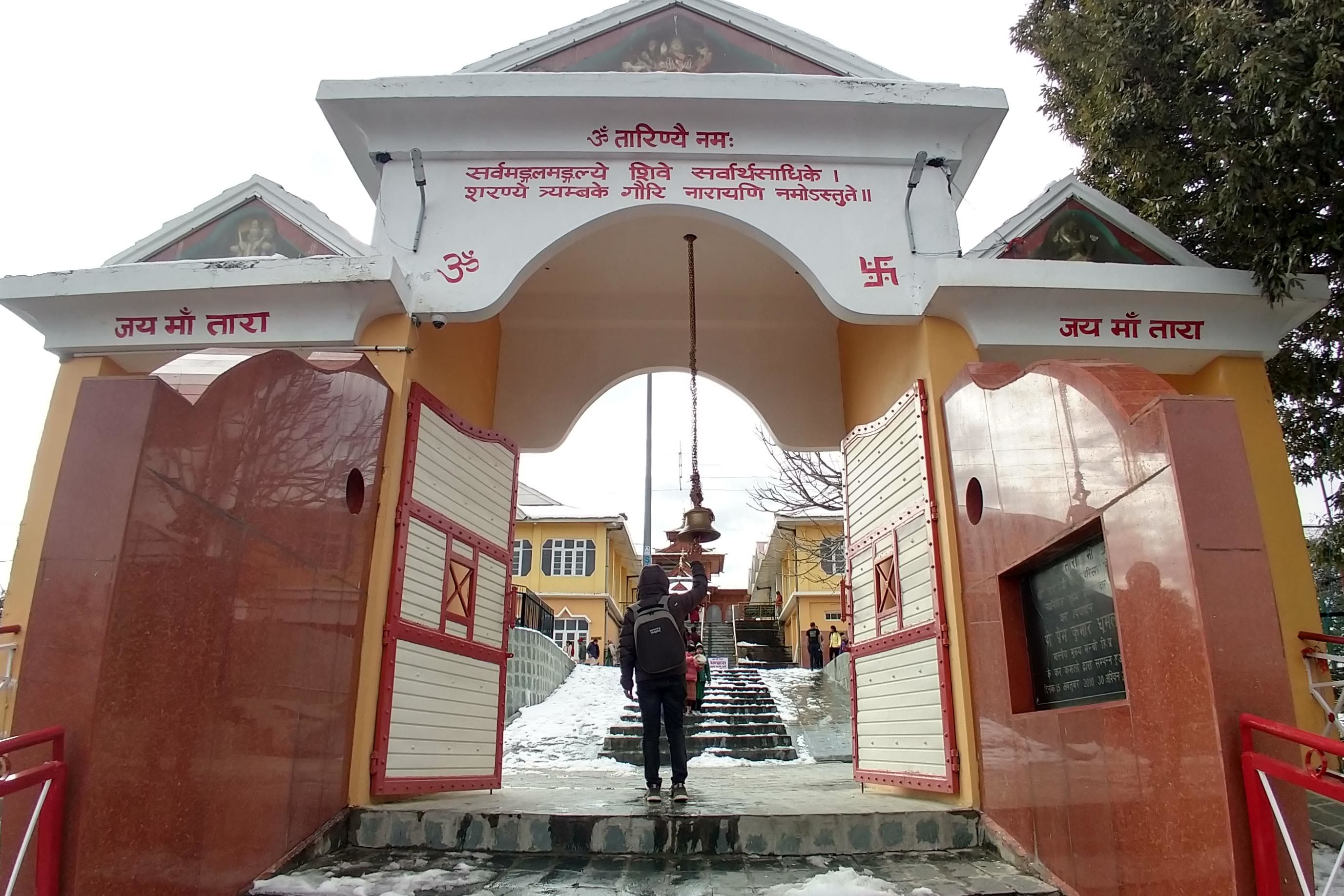 person standing near the front gate of tara devi temple in shimla