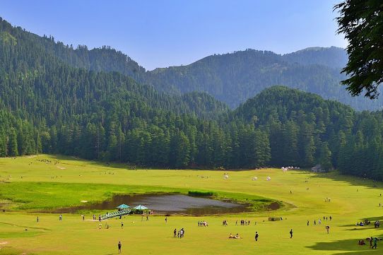 tourists walking near lake in khajjiar