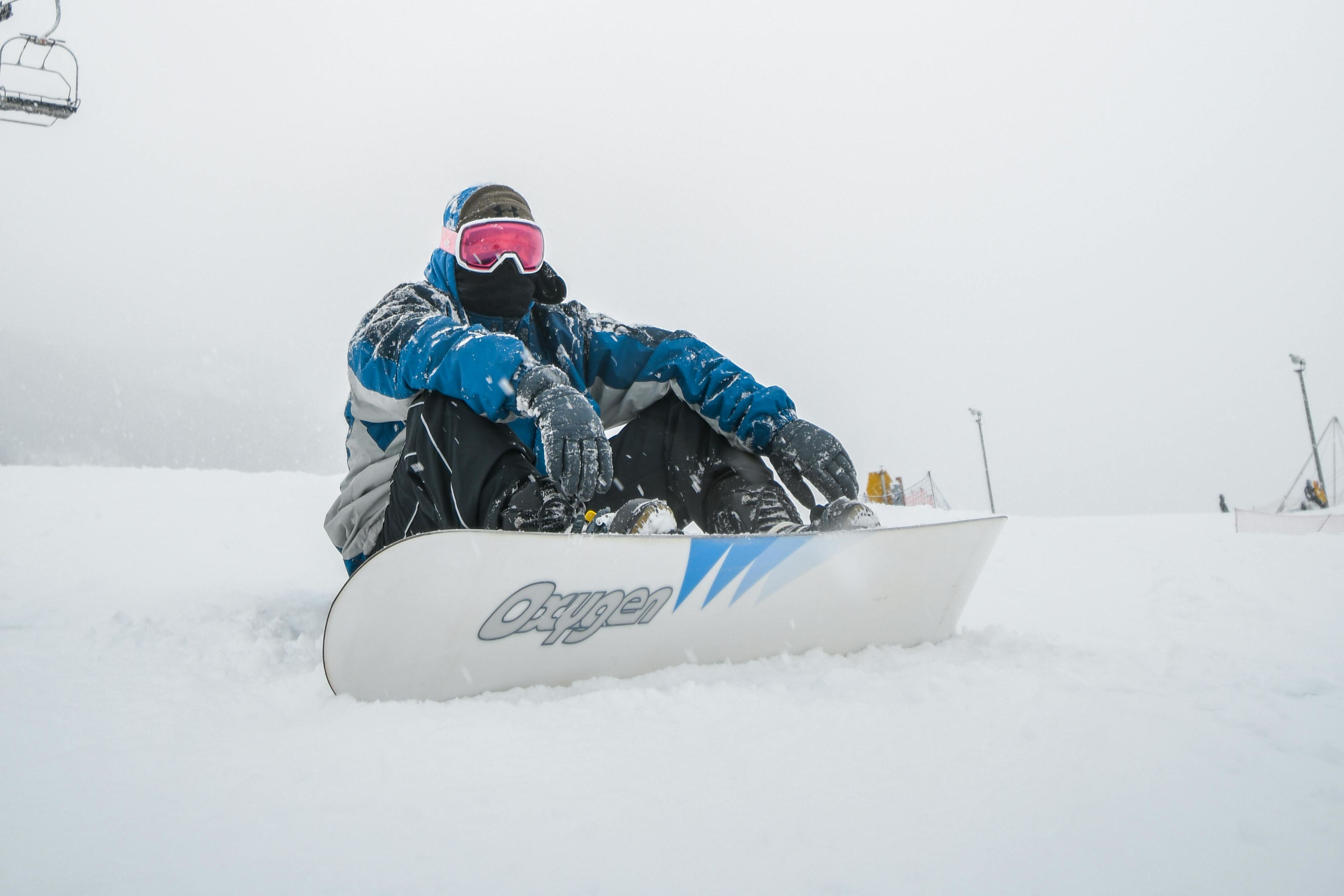 a man sitting in snow under cable car