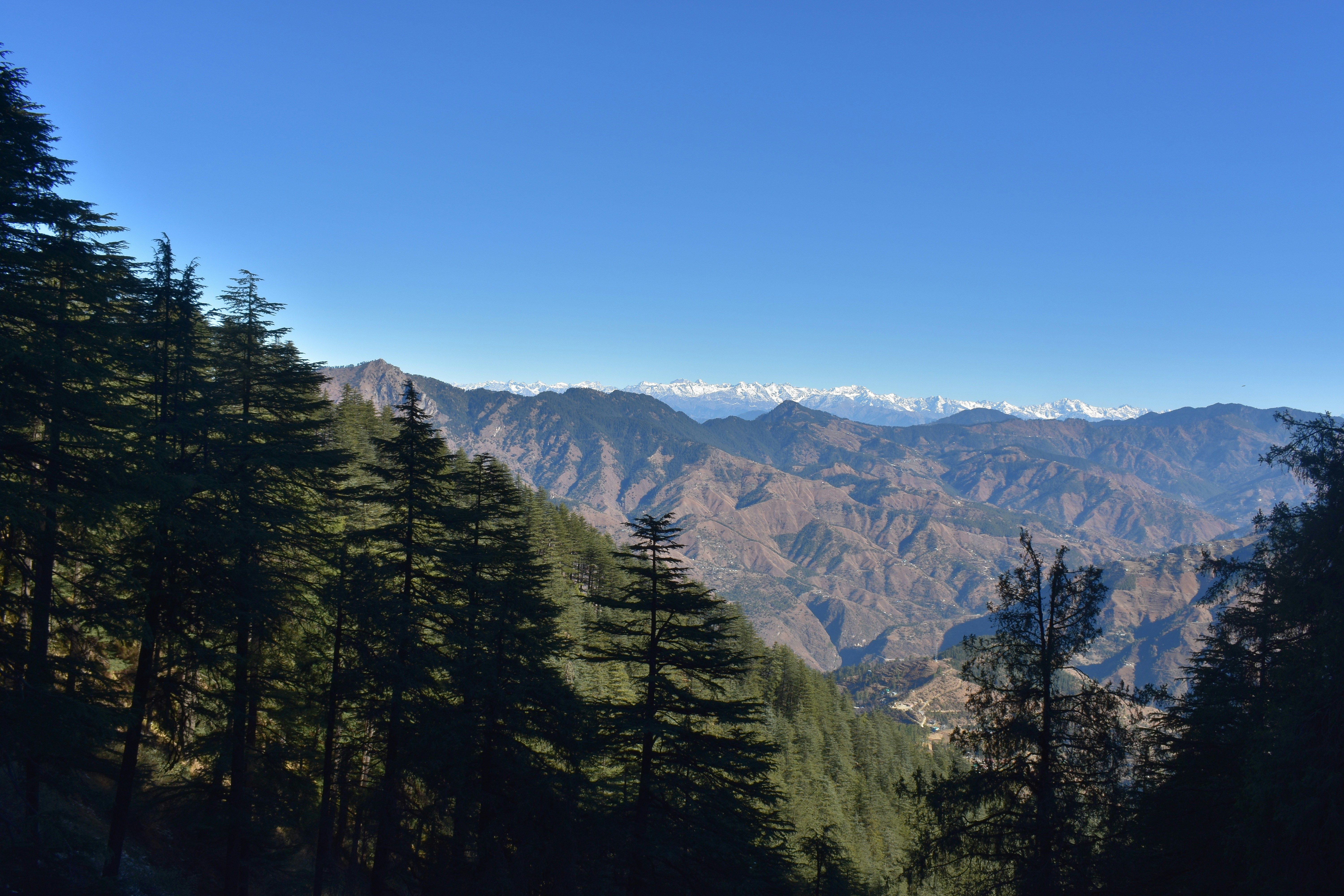 a view of mountain range with clear blue sky in kufri during daytime
