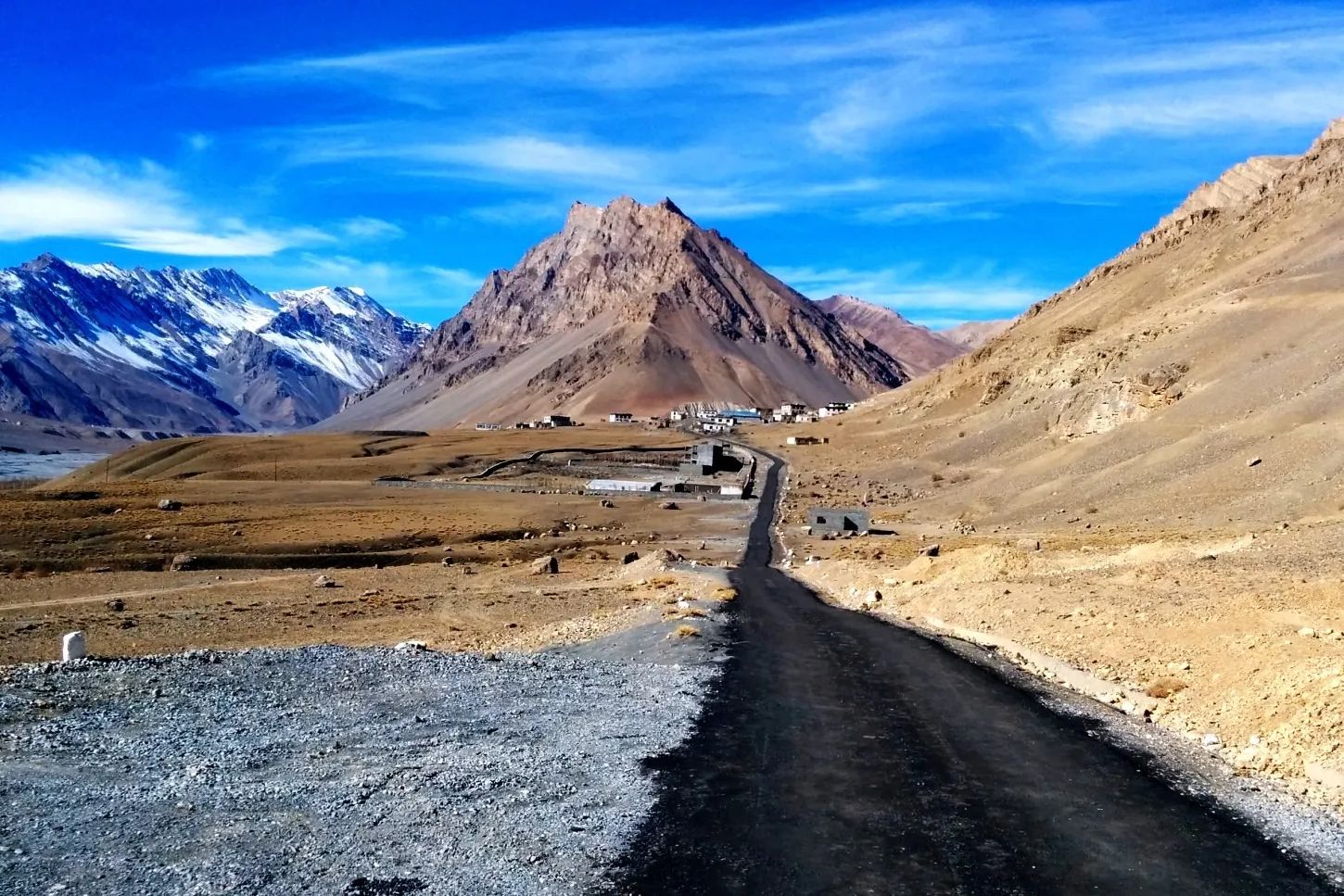 narrow road in spiti valley with brown mountains on both sides