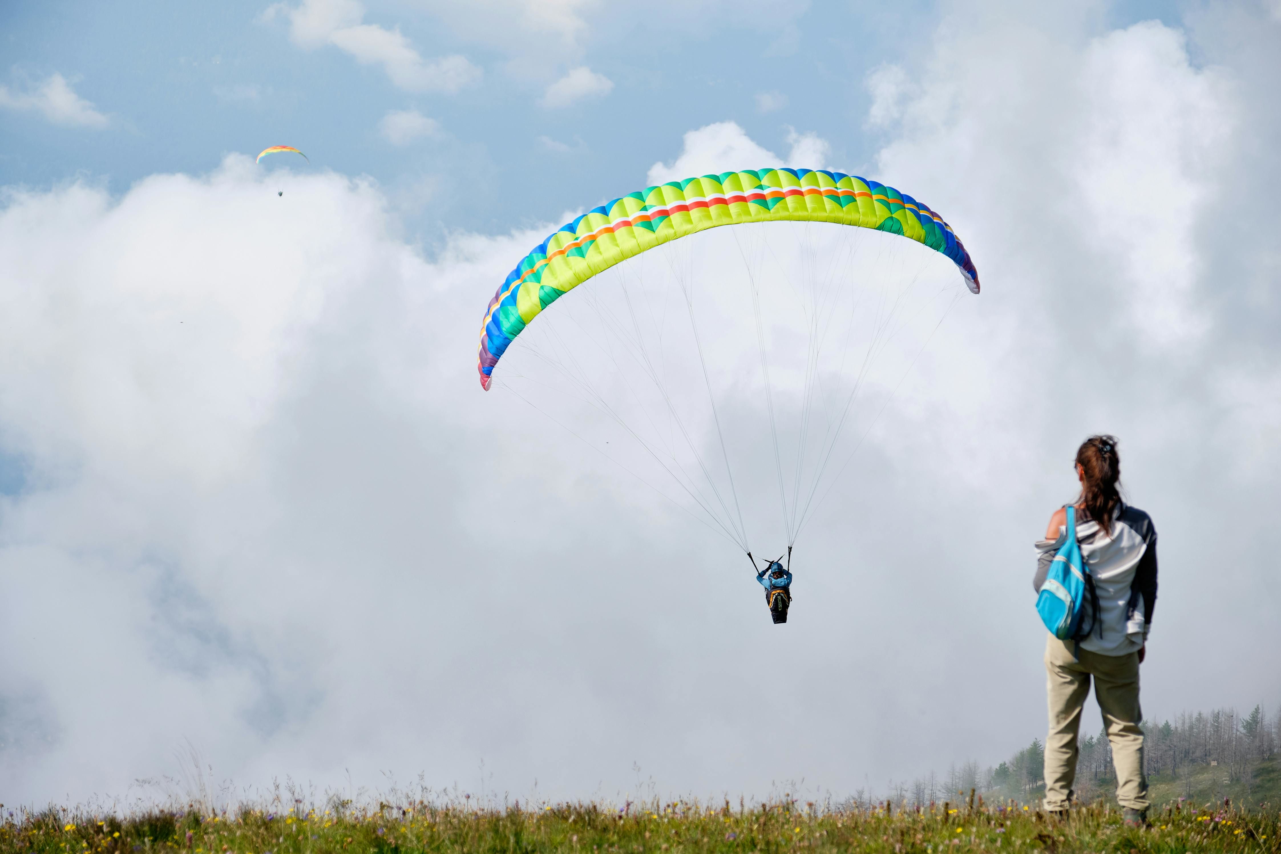 a person paragliding near billing with clouds in the backdrop