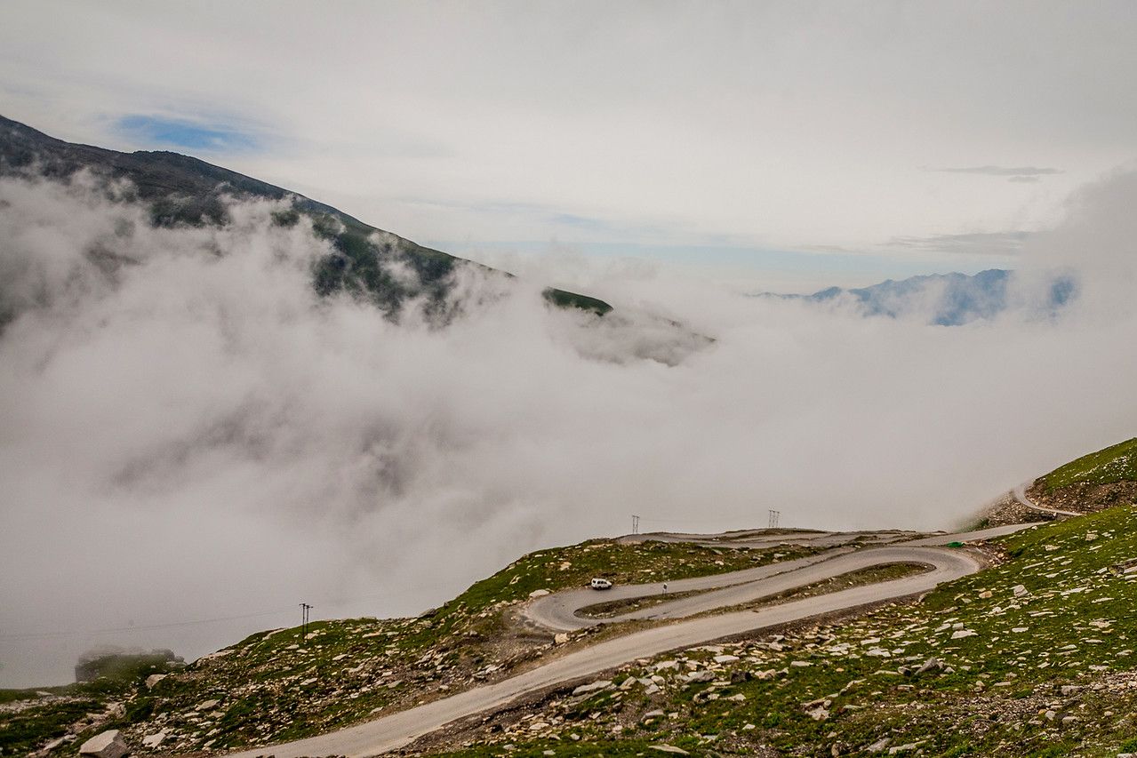 winding mountain road connecting manali to kunzum pass on a cloudy day