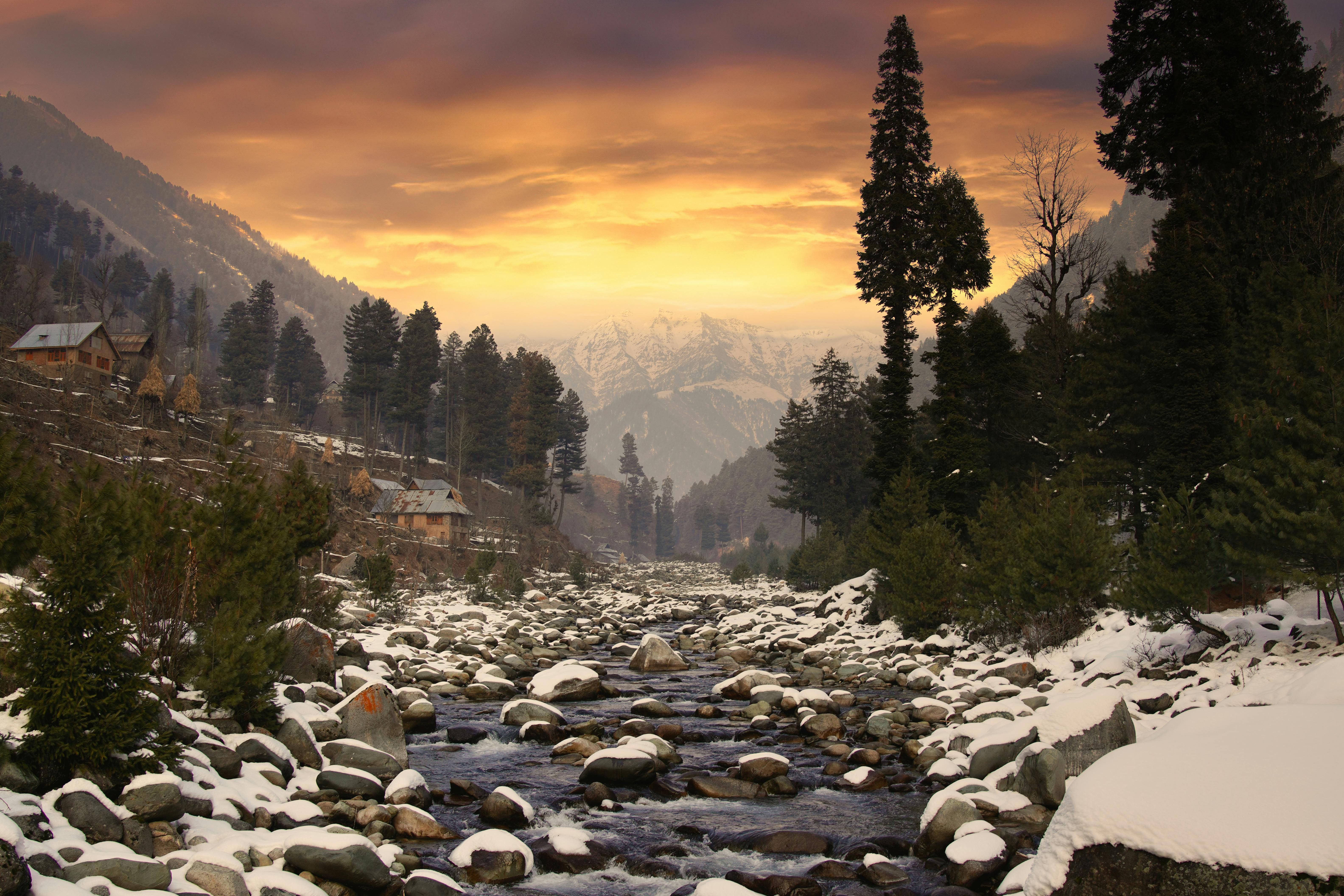 winter sunrise over snowy stream in kashmir